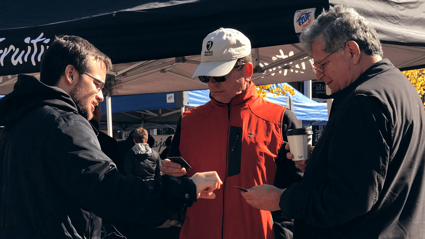 male activist handing out information to two adult males